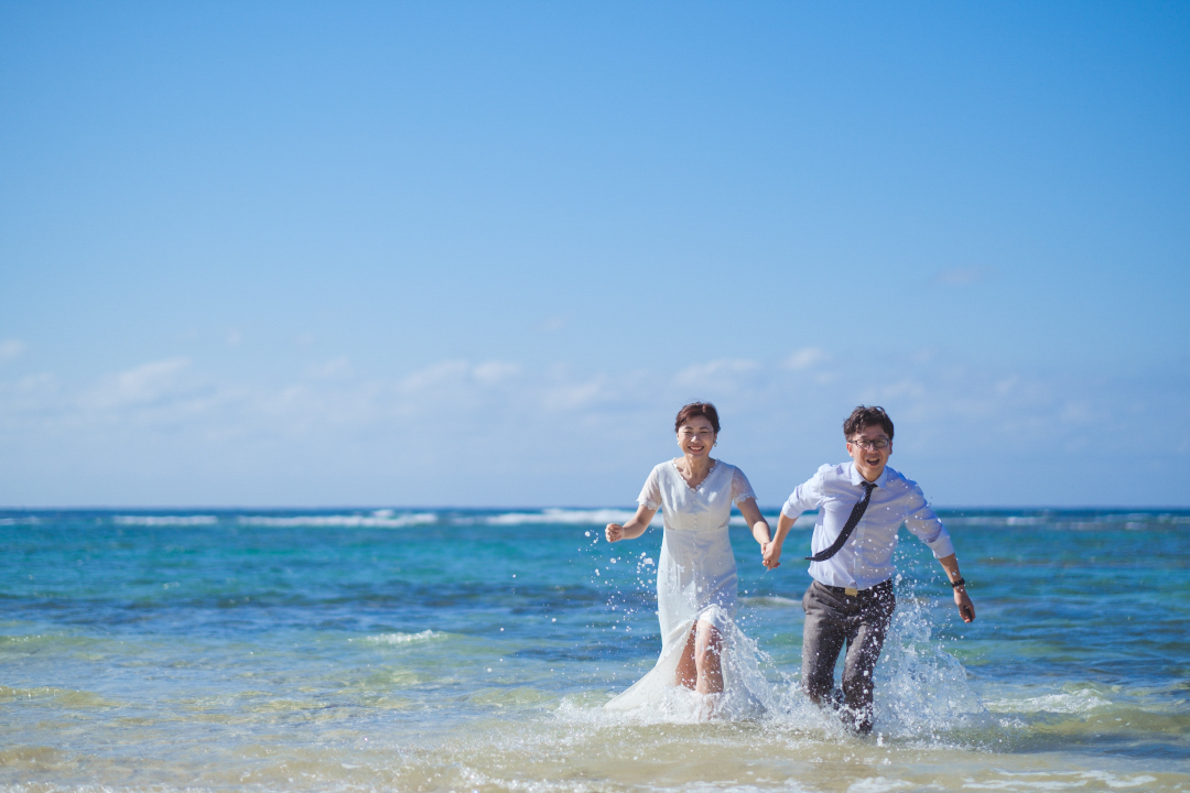 RANWEDDING仙台の沖縄ビーチプランで浜辺を走る新郎新婦